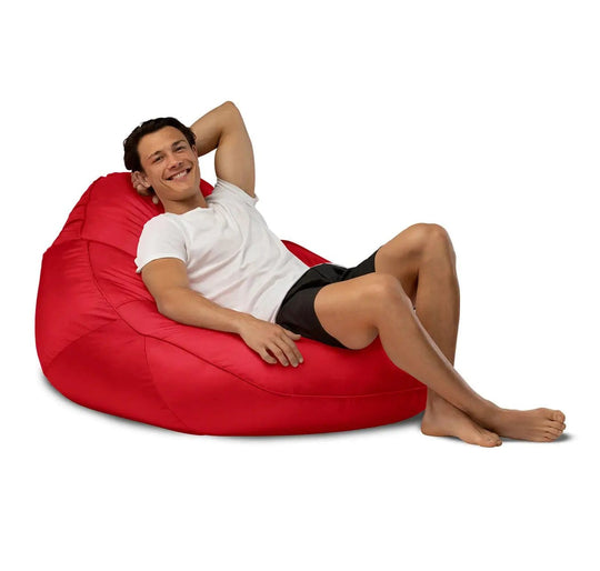 Man relaxing on a red bean bag chair against a white background