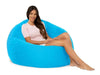 Woman sitting on a large blue bean bag chair against a white background