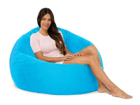 Woman sitting on a large blue bean bag chair against a white background