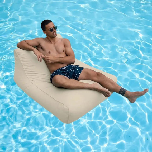 Man lounging on a beige amalfi pool float in a pool