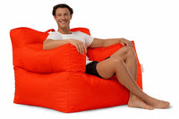 man sitting on a bright red armchair beanbag