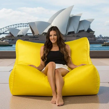 Woman sitting on a yellow bean bag chair with the Sydney Opera House in the background