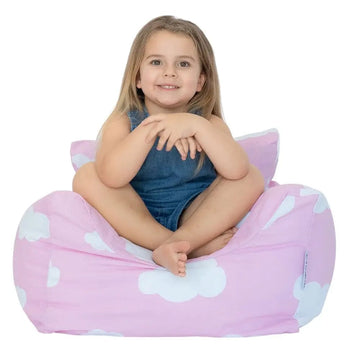 Child sitting on a pink cloud-patterned bean bag chair against a white background