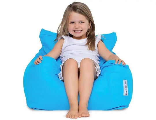 Child sitting on a blue bean bag chair against a white background