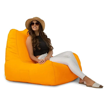 Woman sitting on an orange bean bag chair against a white background