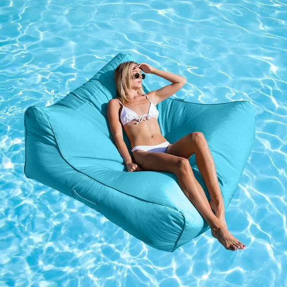 Woman lounging on a blue bean bag in a pool