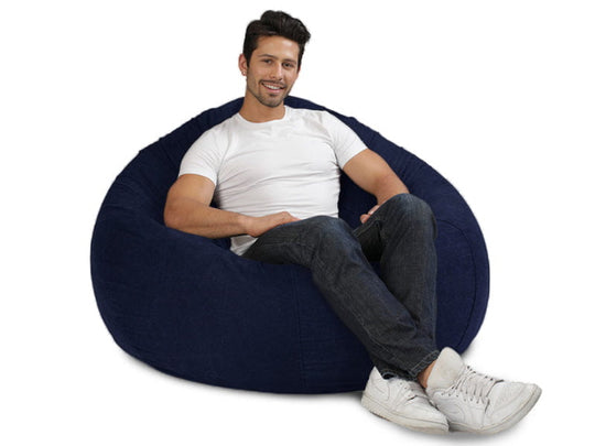 man sitting on a large blue denim bean bag