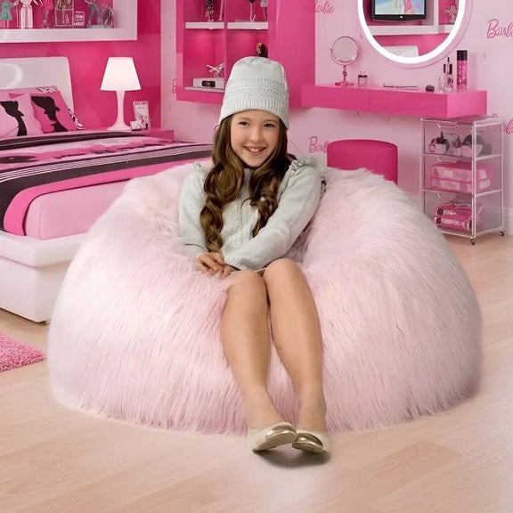 Young girl sitting on a pink bean bag chair in a Barbie-themed room.
