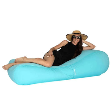 Woman lounging on a blue bean bag lounger against a white background