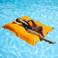 Woman lying on a yellow lounger in a pool