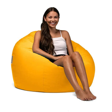 Woman sitting on a yellow bean bag chair against a white background