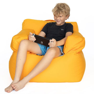Child sitting on a vivid pram kids bean bag chair holding a tablet.